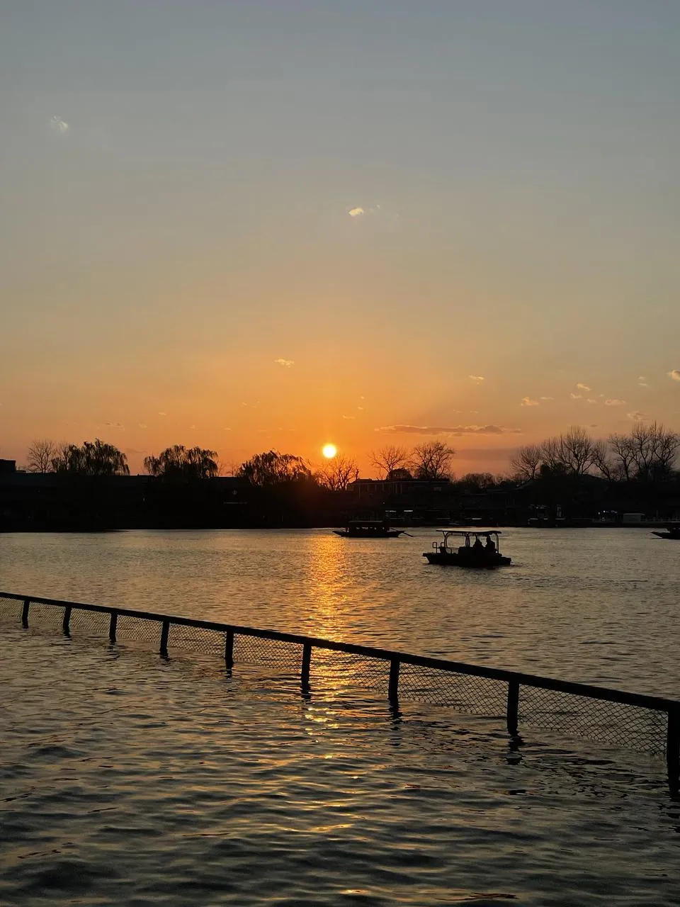 夕阳下的湖面和游船剪影